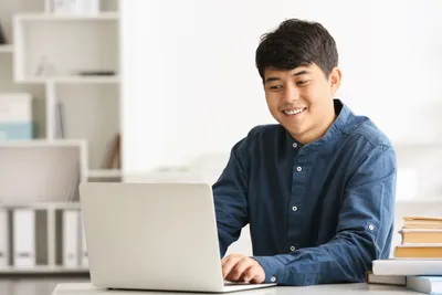 laki laki di depan laptop tersenyum