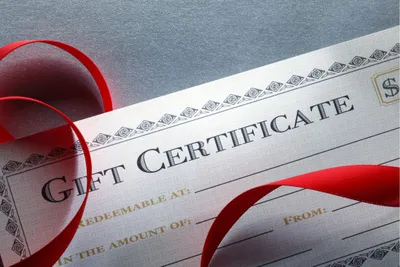 Kertas bertuliskan "GIFT CERTIFICATE" yang artinya sertifikat penghargaan.
