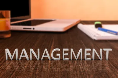 tulisan management di samping laptop dan notebook