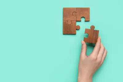 tangan memasang puzzle kayu