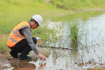 seorang engineer sedang mengambil sampel air