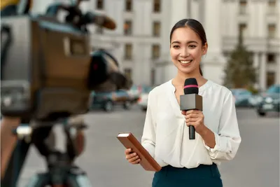 Seorang reporter sedang melaporkan berita secara langsung.