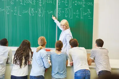 dosen sedang mengajar matematika dan kumpulan mahasiswa sedang belajar di depan papan tulis
