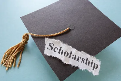 Toga dengan secarik kertas bertuliskan scholarship di atasnya