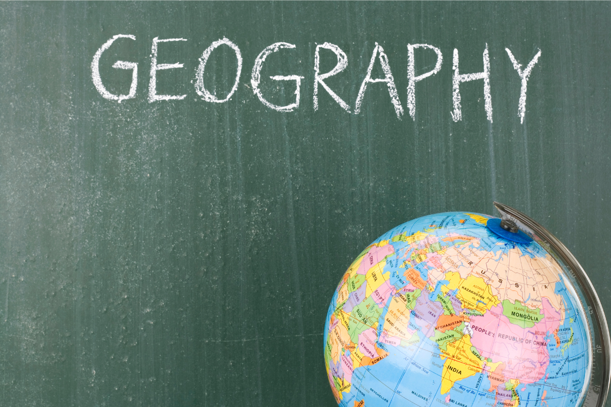 papan tulis dengan tulisan geografi dan globe di depannya