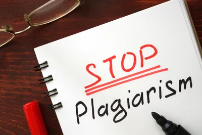 secarik kertas dengan tulisan stop plagiarism