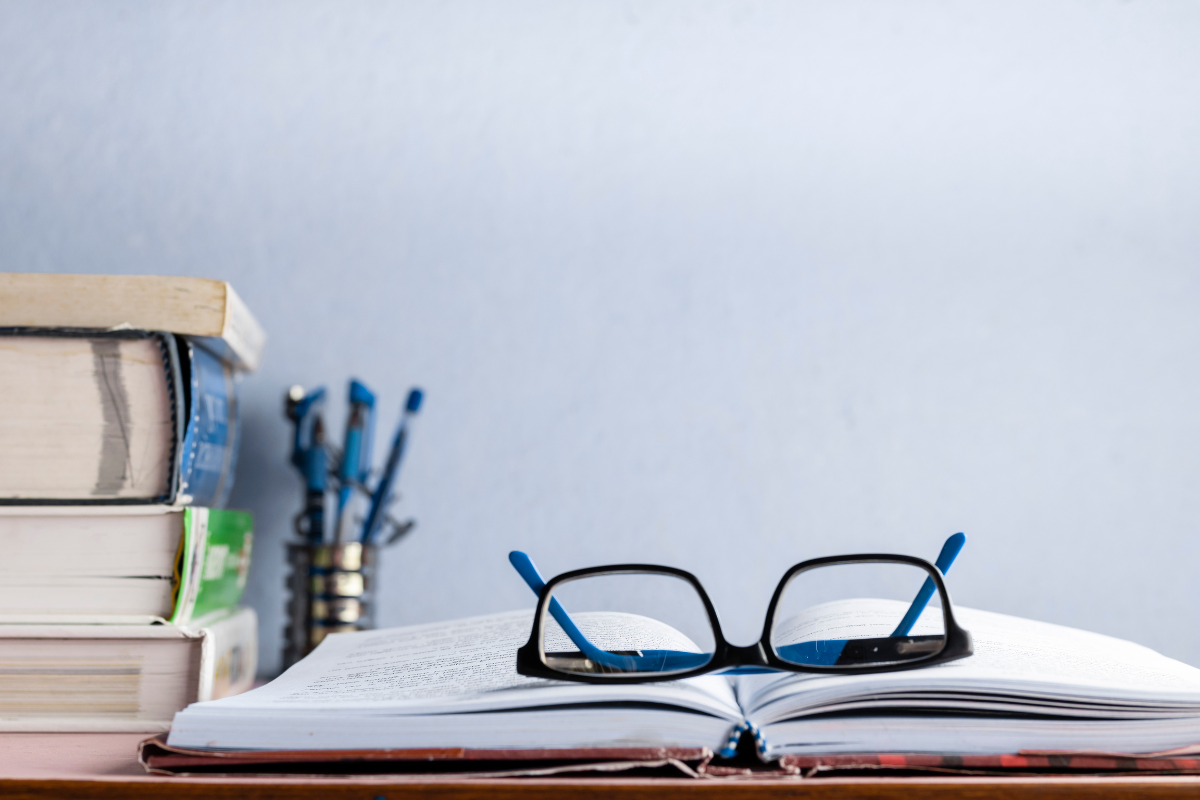 buku pelajaran dan kacamata